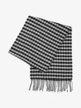 Bufanda de tejido suave con diseño de cuadros vichy en blanco y negro, terminada con flecos en los extremos.