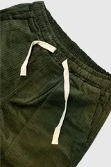 Pantalón de pana verde oliva con cintura elastizada y cordón de algodón. Cuenta con bolsillos laterales, un bolsillo trasero y el parche característico de Polonio.