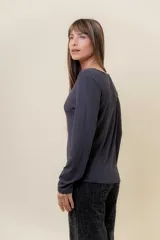 Remera básica de manga larga en color blanco, confeccionada en tela gruesa con elastano. Presenta un diseño liso con escote redondo y un calce cómodo que se adapta al cuerpo sin ajustar.