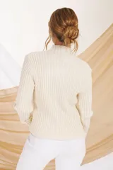 Sweater rojo de punto acanalado, con cuello alto y mangas largas.