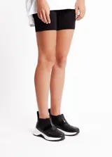 Sneakers negras de cuero vacuno con elásticos laterales y suela blanca de goma antideslizante.