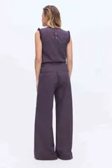 Pantalón de pierna amplia y tiro alto, confeccionado en tejido a rayas con una mezcla de algodón, poliéster y lino. Presenta un diseño de corte sastrero con bolsillos laterales y trabillas para cinturón.