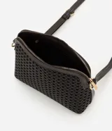 Bolso bandolera Satinato en color marrón oscuro, de diseño compacto y estructurado, confeccionado en poliuretano (PU) texturizado. Presenta trama calada en la parte frontal, cierre superior con cremallera metálica dorada y correa larga ajustable para llevar cruzada.