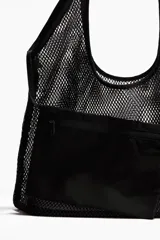 Bolso tipo shopper de malla negra, con asas de hombro y un forro interior o bolsillo pequeño extraíble de tela opaca negra.