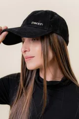 Gorra de diseño clásico con visera curva, confeccionada en material símil gamuza color bordó. Presenta un logo metálico con la palabra Peach en la parte frontal y cuenta con un sistema de ajuste posterior.
