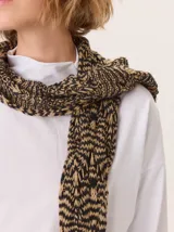 Bufanda de lana tejida con diseño de trama abierta y textura irregular, en tonos amarillo mostaza y blanco.