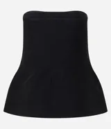 Blusa negra sin breteles, confeccionada en tejido de punto, con diseño ajustado en el busto y detalle de peplum en el ruedo que aporta volumen y movimiento.