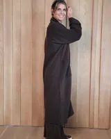 Sacón largo de punto abierto, confeccionado en lana, con diseño holgado, mangas anchas y cuello tipo solapa.