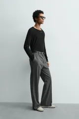 Camiseta negra de corte relaxed fit, confeccionada en tejido ligero con algodón. Presenta cuello redondo y manga ranglán larga.