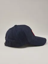 Gorra de béisbol de pana azul marino con parche lateral con el logo de la marca Benson & Thomas.