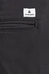 Pantalón chino negro de corte slim fit, con cierre de cremallera y confeccionado en tela con elastano.