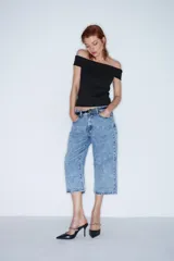 Pantalón capri de jean celeste con efecto lavado, tiro alto, corte recto y largo a la pantorrilla.