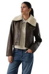 Campera estilo aviador de cuero sintético en color marrón, con cuello de corderito sintético en tono crema. Presenta cierre frontal, bolsillos laterales y un bolsillo pequeño con cierre en el pecho.
