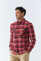 Sobrecamisa de algodón a cuadros color ladrillo, con interior de corderito, cierre con botones, bolsillos tipo cartera y logo en goma. El modelo usa talle M.