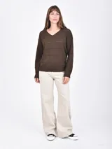 Buzo de tejido de punto color marrón oscuro, con cuello en V y detalles calados horizontales a lo largo del cuerpo y mangas.
