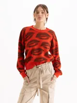 Sweater tejido semi pesado color rojo con estampado de labios en marrón, de corte holgado, escote redondo y mangas largas con hombros caídos.