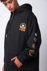 Buzo canguro oversize de algodón rústico, color gris claro, con capucha y cordones ajustables con logo estampado. Presenta un diseño gráfico pequeño en el pecho y detalles estampados en la manga.