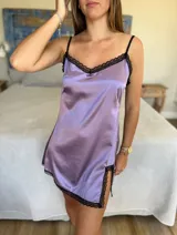 Camisolín corto color lila de satén con breteles finos regulables y detalles de encaje negro en escote y ruedo. Presenta tajo lateral.