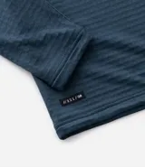Remera deportiva de manga larga con cuello alto y cierre frontal parcial. Presenta una textura acanalada en toda la prenda y detalles reflectivos en los hombros.