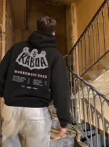 Canguro de felpa gris melange con capucha, manga larga y estampa trasera de estilo rockero con tipografía y calavera.