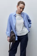 Remera blanca de silueta amplia y calce relajado, confeccionada en tela suave y liviana, con cuello redondo, mangas cortas con vuelta y hombros caídos. Cuenta con un delicado bordado frontal en color azul con la inscripción "LE SOLEIL TOUTE L'ANNÉE sur la Côte d'Azur".
