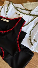 Musculosa de morley verde militar con escote redondo y detalles de bordado artesanal en crochet en los bordes.