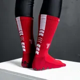 Medias deportivas de caña media color fucsia, con suela antideslizante de puntos negros y logo de la marca estampado en la parte superior.