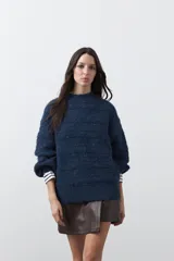Sweater de punto con textura, color azul, de silueta relajada, cuello redondo y mangas largas abullonadas con puños ajustados.