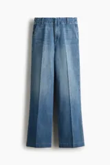 Jean de denim de algodón rígido, color azul con efecto lavado, de tiro alto y corte recto holgado. Cuenta con bolsillos al bies y pliegues marcados al frente y en la espalda.