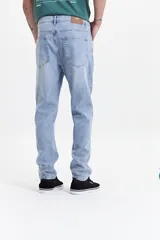 Pantalón jean gris de corte slim, tiro medio y con presillas para cinturón.