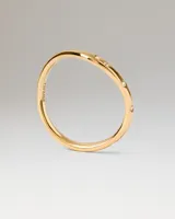 Anillo de oro con diseño ondulado y pequeños cristales incrustados.