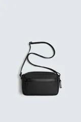 Bandolera negra con acabado engomado y textura. Cuenta con un compartimento principal con cierre de cremallera, un bolsillo plano interior y un asa de hombro ajustable y extraíble.