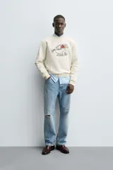Sudadera de cuello redondo y manga larga con calce relajado. Presenta un bordado frontal de un conejo con flores y detalles en contraste, con terminaciones en rib en puños y ruedo.
