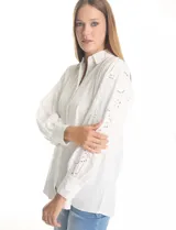 Camisa blanca de la marca Liv Los Ángeles, con cuello con solapa y cierre frontal de botones. Presenta mangas largas con detalles calados y puños anchos con botones.