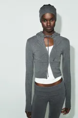 Sudadera cropped de punto con cierre frontal de cremallera metálica, capucha ajustable con cordones y mangas largas con puños en rib.