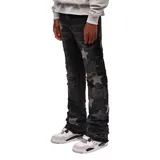 Jeans negros de corte flare con diseño de estrellas aplicadas en tono grisáceo y detalles desgastados con roturas en las piernas.