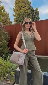 Bandolera de diseño práctico con combinación de texturas en tonos tierra, confeccionada en tela y símil cuero. Cuenta con un compartimento principal con cierre, un bolsillo frontal con cierre y correa ajustable para llevar al hombro o cruzada.