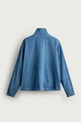 Camisa polo de corte relajado confeccionada en denim ligero de algodón con efecto lavado. Presenta cuello subido, cierre frontal con botonadura oculta por solapa, manga larga, bolsillo de plastrón en el pecho y bajo ajustable con cordón.