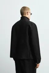 Blazer de corte relajado confeccionado en mezcla de algodón y lino. Presenta un diseño sin solapas, cierre frontal de un botón, manga larga y bolsillos ocultos en las costuras laterales. Interior sin forro.