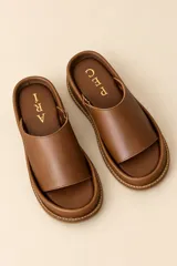 Sandalias de cuero vacuno con plataforma baja, capellada ancha de pelo con estampado animal print tipo dálmata en tonos marrón oscuro y blanco, y plantilla marrón.