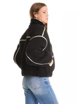 Campera negra de símil corderito, marca Elan. Tiene cuello alto, cierre frontal con solapa y botones, bolsillos inclinados en la parte delantera y ruedo y puños elastizados. Forro interno a tono.