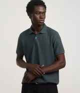 Camisa polo de algodón y poliéster texturizada color verde oscuro, de manga corta, con cuello polo y cierre frontal de botones.