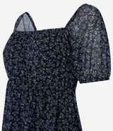 Vestido corto evasê de tule ligero color azul marino con estampado floral liberty fullprint en blanco. Posee escote recto, mangas cortas abullonadas y canesú fruncido en el busto.