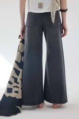 Pantalón jean gris oscuro de tiro medio y piernas anchas, con diseño de cinco bolsillos y cierre frontal con botón y cremallera.