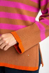 Sweater de punto con diseño de rayas horizontales en azul y rojo, cuello redondo y puños con terminación en color marrón.
