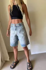 Bermuda de jean celeste con efecto lavado, corte holgado y largo a la rodilla.