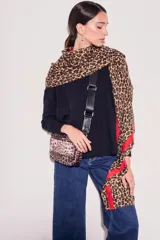 Sweater de tejido de punto en color negro, con corte oversize, cuello redondo y mangas largas con puños acanalados.