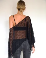 Capa de encaje negro con diseño asimétrico y caída holgada, ideal para usar sobre otras prendas.