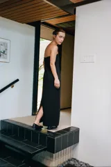 Vestido largo negro de viscosa, con escote recto tipo palabra de honor y hombros descubiertos, de corte recto y ajuste con cierre lateral oculto.