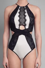 Body blanco con paneles de encaje negro, escote halter con abertura en el pecho y espalda descubierta.